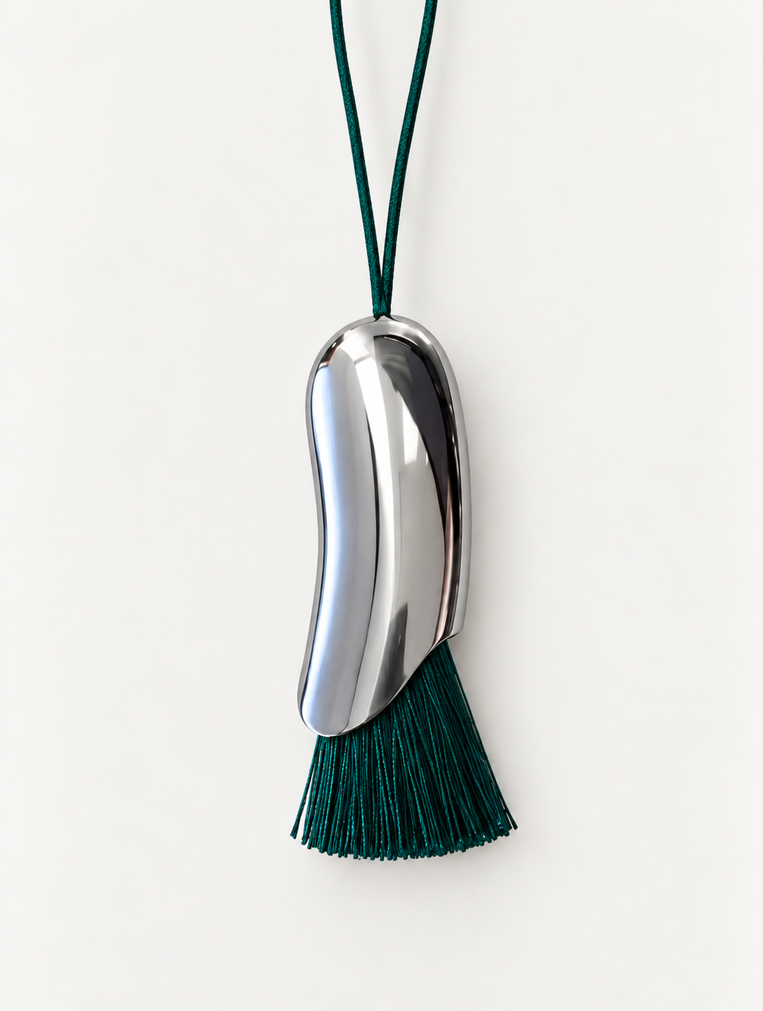 silver tone bean shape pendant necklace with green tassel and matching cord 